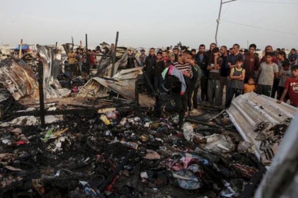 Palestinians look at the destruction after an Israeli strike where displaced people were staying in Rafah, Gaza Strip, Monday, May 27, 2024. 